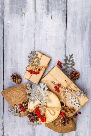 Christmas zero waste concept. New Year eco friendly packaging. Festive boxes in craft paper and sacks with different organic decorations. Wooden boards background, copy space, top viewの写真素材