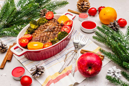 Baked duck breast on the bone with vegetables and sauce. Christmas dinner concept, New Year table setting. Stone concrete backgroundの写真素材