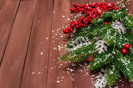 Christmas background. New Year fir tree, dog rose, fresh leaves and artificial snow. Wooden boards backdrop, copy spaceの写真素材