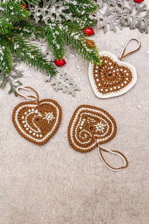Christmas background. New Year fir tree, dog rose, fresh leaves, crocheted ginger cookies hearts and artificial snow. Stone concrete backdrop, copy space, top viewの写真素材