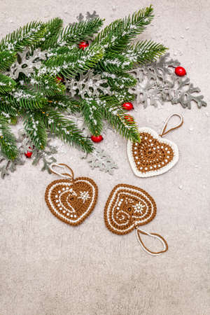 Christmas background. New Year fir tree, dog rose, fresh leaves, crocheted ginger cookies hearts and artificial snow. Stone concrete backdrop, copy space, top viewの写真素材