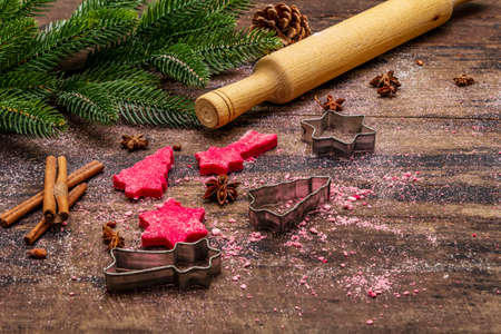 Cooking red ginger cookies. Traditional Christmas pastries. Festive culinary background. Fir tree, spices, cookie cutters, raw dough, rolling pin, wooden boardsの写真素材