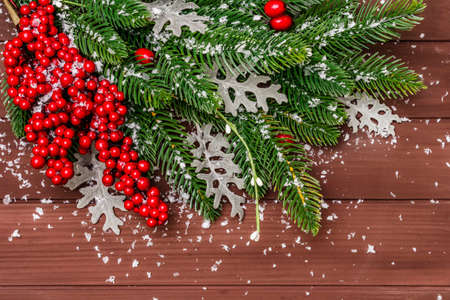 Christmas background. New Year fir tree, dog rose, fresh leaves and artificial snow. Wooden boards backdrop, top view, close upの写真素材