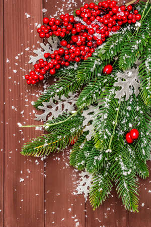 Christmas background. New Year fir tree, dog rose, fresh leaves and artificial snow. Wooden boards backdrop, top view, close upの写真素材