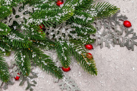 Christmas background. New Year fir tree, dog rose, fresh leaves and artificial snow. Stone concrete backdrop, top view, close upの写真素材