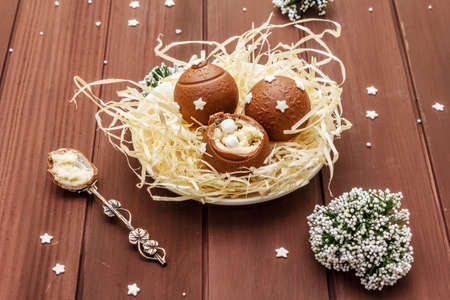 Homemade chocolate candies with star sprinkles. Festive sweet dessert, Christmas (New Year) spirit. Wooden boards background, close upの写真素材