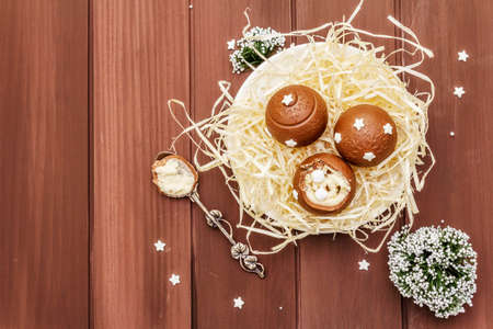 Homemade chocolate candies with star sprinkles. Festive sweet dessert, Christmas (New Year) spirit. Wooden boards background, copy space, top viewの写真素材