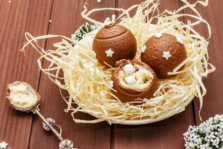 Homemade chocolate candies with star sprinkles. Festive sweet dessert, Christmas (New Year) spirit. Wooden boards background, close upの写真素材