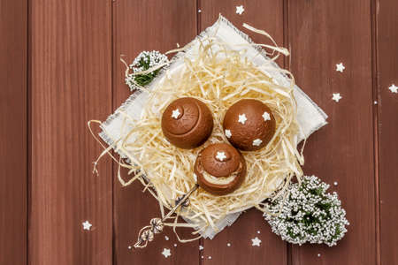 Homemade chocolate candies with star sprinkles. Festive sweet dessert, Christmas (New Year) spirit. Wooden boards background, copy space, top viewの写真素材