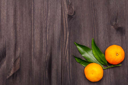 Fresh ripe tangerines with leaves. New Year or Christmas wooden background. Festive good mood concept, copy space, top viewの写真素材