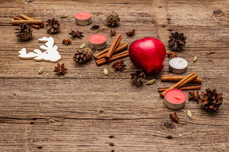 Spirit Christmas background. Apple, candles, spices, deer, cones. Nature New Year decorations, vintage wooden boards, copy spaceの写真素材