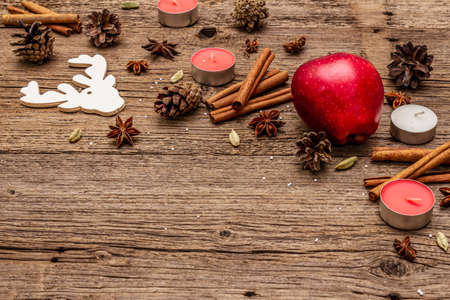 Spirit Christmas background. Apple, candles, spices, deer, cones. Nature New Year decorations, vintage wooden boards, copy spaceの写真素材