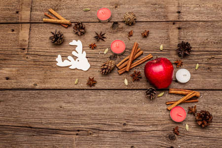 Spirit Christmas background. Apple, candles, spices, deer, cones. Nature New Year decorations, vintage wooden boards, copy space, top viewの写真素材