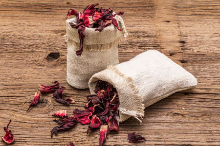 Dry hibiscus petals. Ingredient for cooking hot tea. Healthy food and self-care concept. Old wooden boards backgrounds, copy space, close upの写真素材