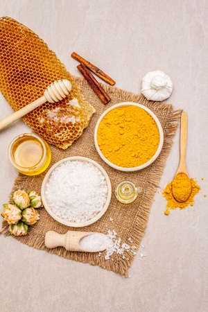 Personal care with natural ingredients. Healthy spa concept. Turmeric, sea salt, honey, cinnamon, oil. Stone concrete background, close up, top viewの写真素材