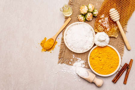 Personal care with natural ingredients. Healthy spa concept. Turmeric, sea salt, honey, cinnamon, oil. Stone concrete background, copy space, top viewの写真素材