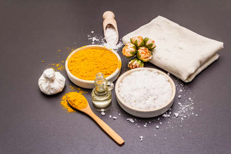 Personal care with natural ingredients. Healthy spa concept. Turmeric, sea salt, oil, towel. Stone concrete background, close upの写真素材