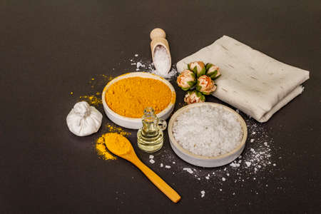 Personal care with natural ingredients. Healthy spa concept. Turmeric, sea salt, oil, towel. Stone concrete background, close upの写真素材