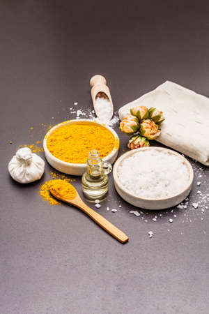 Personal care with natural ingredients. Healthy spa concept. Turmeric, sea salt, oil, towel. Stone concrete background, copy spaceの写真素材