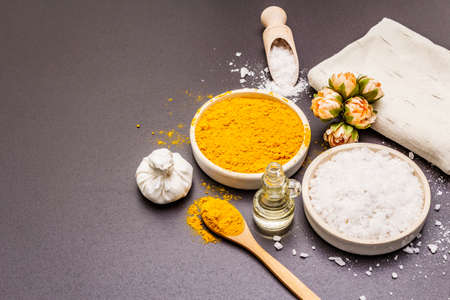 Personal care with natural ingredients. Healthy spa concept. Turmeric, sea salt, oil, towel. Stone concrete background, copy spaceの写真素材