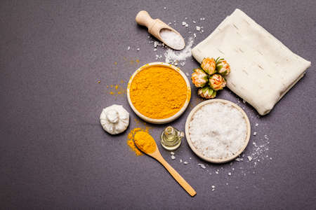 Personal care with natural ingredients. Healthy spa concept. Turmeric, sea salt, oil, towel. Stone concrete background, copy space, top viewの写真素材