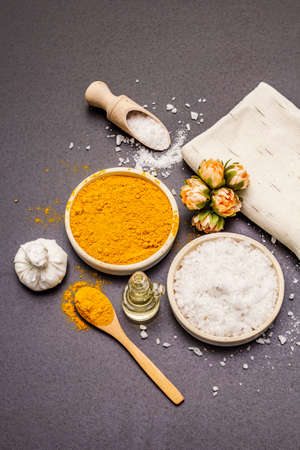 Personal care with natural ingredients. Healthy spa concept. Turmeric, sea salt, oil, towel. Stone concrete background, copy space, top viewの写真素材