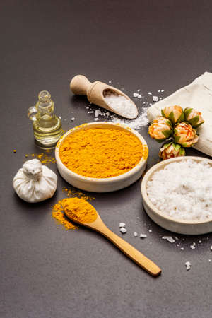 Personal care with natural ingredients. Healthy spa concept. Turmeric, sea salt, oil, towel. Stone concrete background, copy spaceの写真素材