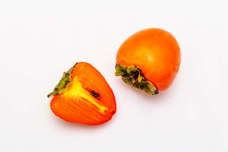 Ripe single persimmon. Fresh whole fruit, half sliced. Isolated on white background, copy space, top viewの写真素材