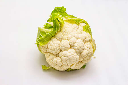 Ripe single cauliflower. Fresh whole head of cabbage, green leaves. Isolated on white background, copy spaceの写真素材