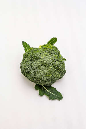 Ripe single broccoli. Fresh whole head of cabbage, green leaves. Isolated on white background, copy space, top viewの写真素材