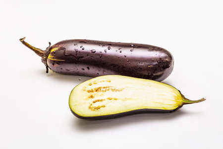 Ripe single eggplant. Fresh whole and half vegetable. Isolated on white background, close upの写真素材