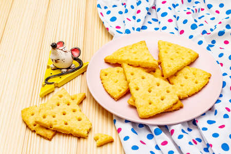 Funny kids cookies. Festive cheese crackers, New Year snack concept. Food, mouse sculpture, napkin. Wooden planks background, close upの写真素材