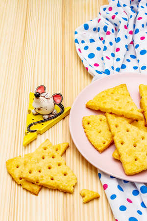 Funny kids cookies. Festive cheese crackers, New Year snack concept. Food, mouse sculpture, napkin. Wooden planks background, copy space, close upの写真素材