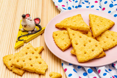 Funny kids cookies. Festive cheese crackers, New Year snack concept. Food, mouse sculpture, napkin. Wooden planks background, close upの写真素材
