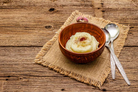 Homemade Thanksgiving garlic mashed potatoes with salt and pepper. Sackcloth napkin, spoons, old wooden boards background, copy spaceの写真素材