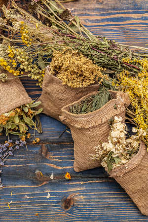 Herbal harvest collection and bouquets of wild herbs. Alternative medicine. Natural pharmacy, self-care concept. Old wooden boards background, close upの写真素材