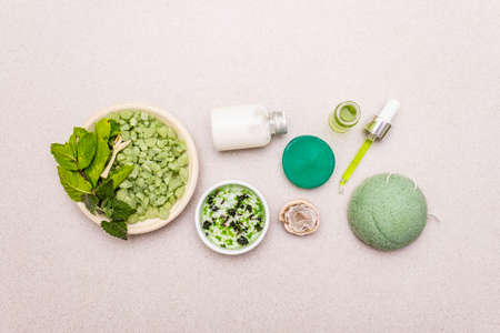 Healthy self-care. Minimalistic organic lifestyle. Comfort and natural pharmacy. Sea salt, herbal oil, dry and fresh leaves. Bowls, stone concrete background, copy space, top viewの写真素材