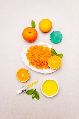 Healthy self-care. Minimalistic organic lifestyle. Comfort and natural pharmacy. Sea salt, herbal oil, mandarin and fresh mint leaves. Bowls, stone concrete background, top view, close upの写真素材