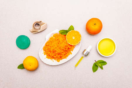 Healthy self-care. Minimalistic organic lifestyle. Comfort and natural pharmacy. Sea salt, herbal oil, mandarin and fresh mint leaves. Bowls, stone concrete background, top viewの写真素材
