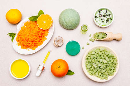 Healthy self-care. Minimalistic organic lifestyle. Comfort and natural pharmacy. Set of sea salt, herbal oil, mandarin and fresh mint leaves. Bowls, stone concrete background, top view, close upの写真素材