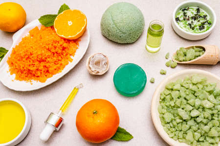 Healthy self-care. Minimalistic organic lifestyle. Comfort and natural pharmacy. Set of sea salt, herbal oil, mandarin and fresh mint leaves. Bowls, stone concrete background, close upの写真素材