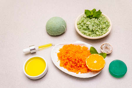 Healthy self-care. Minimalistic organic lifestyle. Comfort and natural pharmacy. Set of sea salt, herbal oil, mandarin and fresh mint leaves. Bowls, stone concrete background, close upの写真素材