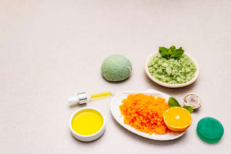 Healthy self-care. Minimalistic organic lifestyle. Comfort and natural pharmacy. Set of sea salt, herbal oil, mandarin and fresh mint leaves. Bowls, stone concrete background, copy spaceの写真素材