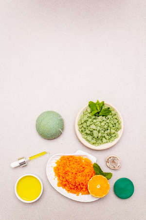 Healthy self-care. Minimalistic organic lifestyle. Comfort and natural pharmacy. Set of sea salt, herbal oil, mandarin and fresh mint leaves. Bowls, stone concrete background, top view, copy spaceの写真素材