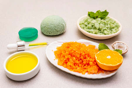 Healthy self-care. Minimalistic organic lifestyle. Comfort and natural pharmacy. Set of sea salt, herbal oil, mandarin and fresh mint leaves. Bowls, stone concrete background, close upの写真素材
