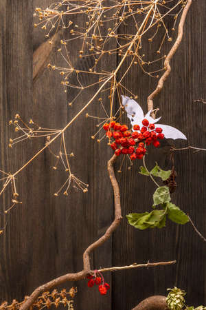 Halloween decoration concept - black bat, dried rowan, leaves and branch. Dark wooden background. Wallpaper, backdrop, card, flat lay, place for textの写真素材
