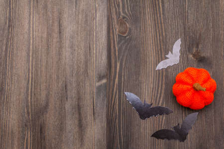 Halloween decoration concept - black bats and orange pumpkin on dark wooden background. Wallpaper, backdrop, card, flat lay, place for text, copy space, top viewの写真素材