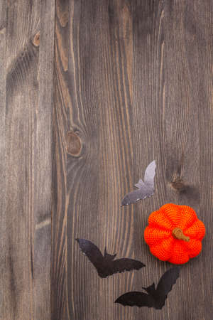 Halloween decoration concept - black bats and orange pumpkin on dark wooden background. Wallpaper, backdrop, card, flat lay, place for text, copy space, top viewの写真素材