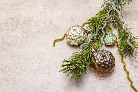 Vintage Christmas tree toys. New Year holiday concept. Evergreen pine branch, stone concrete background, copy spaceの写真素材