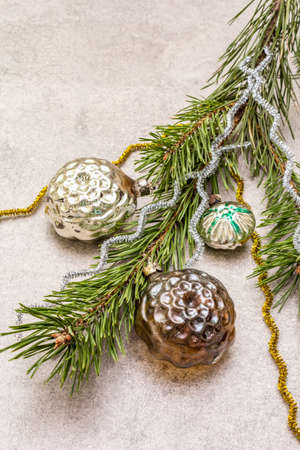 Vintage Christmas tree toys. New Year holiday concept. Evergreen pine branch, stone concrete background, close upの写真素材